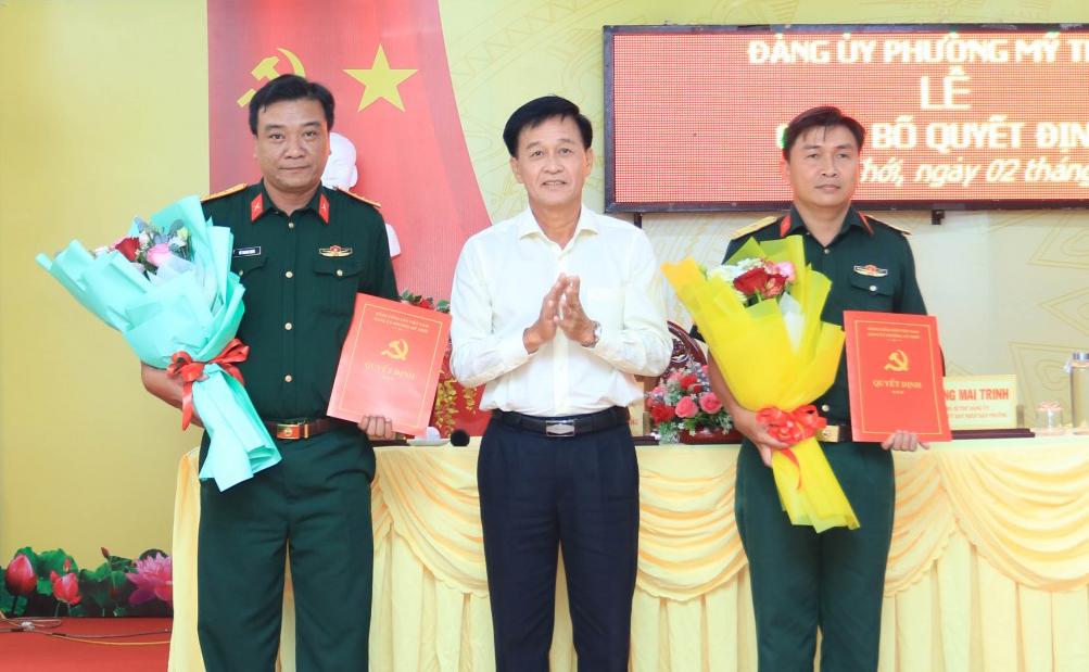 Đồng chí Trần Minh Nhựt, Tỉnh ủy viên, Bí thư Đảng ủy, Chủ tịch HĐND phường Mỹ Thới trao quyết định và tặng hoa chúc mừng Ban Chỉ huy Quân sự phường