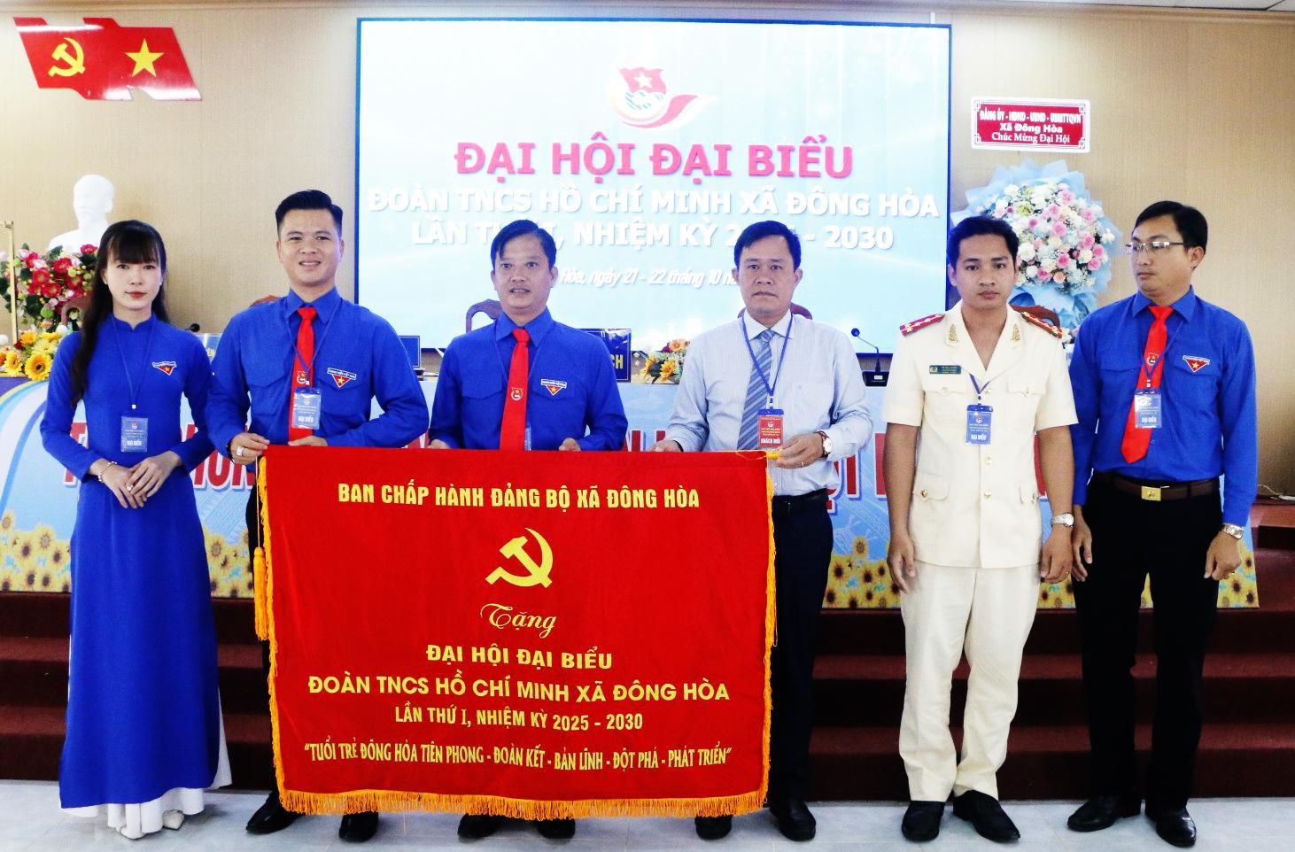 Bí thư Đảng ủy xã Đông Hòa Lê Ngọc Tùng (thứ ba, từ phải qua) trao bức trướng cho đoàn chủ tịch.