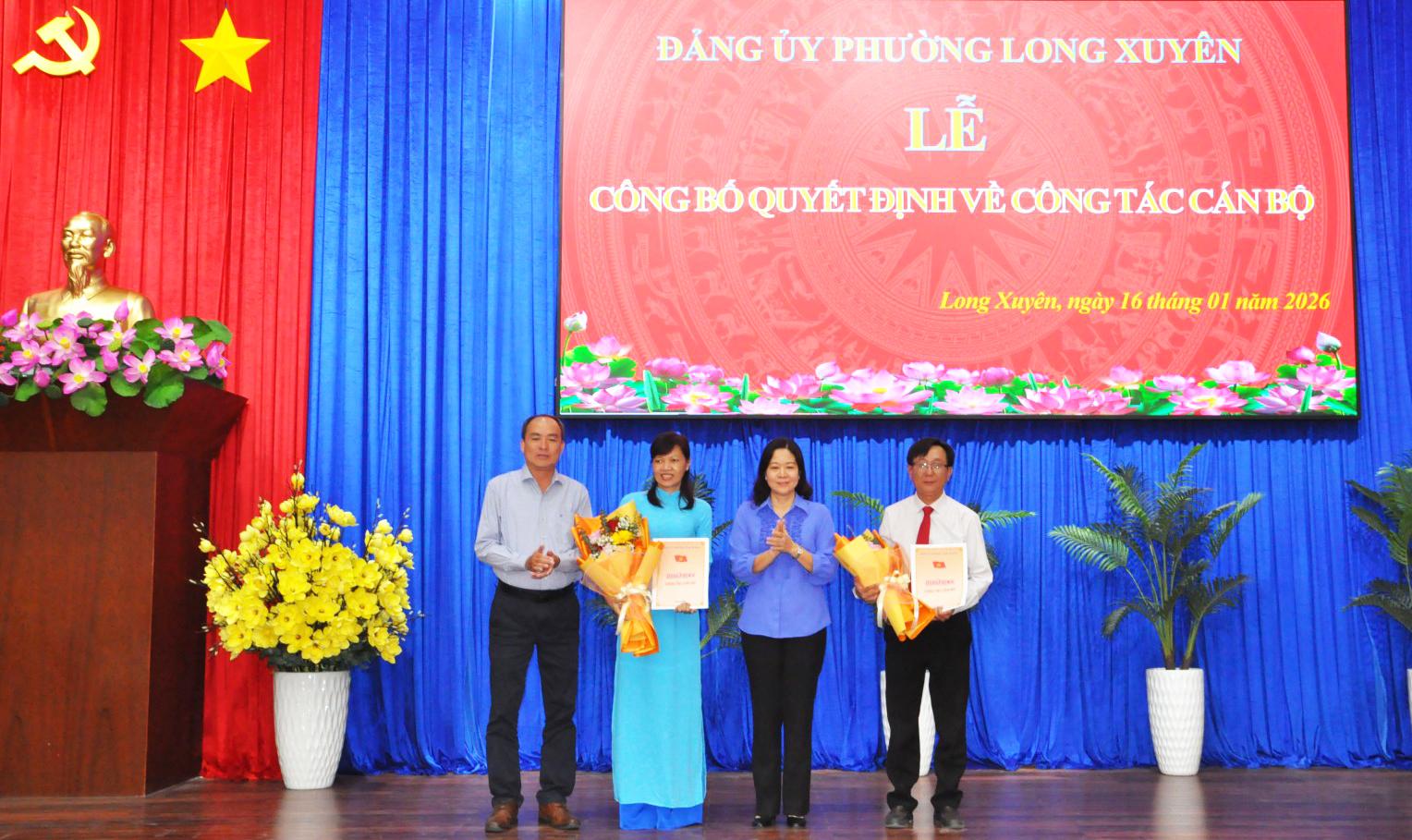Đồng ch&iacute; L&acirc;m Quang Thi, Tỉnh ủy vi&ecirc;n, B&iacute; thư Đảng ủy phường Long Xuy&ecirc;n v&agrave; Ph&oacute; B&iacute; thư Thường trực Đảng ủy V&otilde; Thị Xu&acirc;n Kiều trao Quyết định, tặng hoa ch&uacute;c mừng cho 2 c&aacute;n bộ