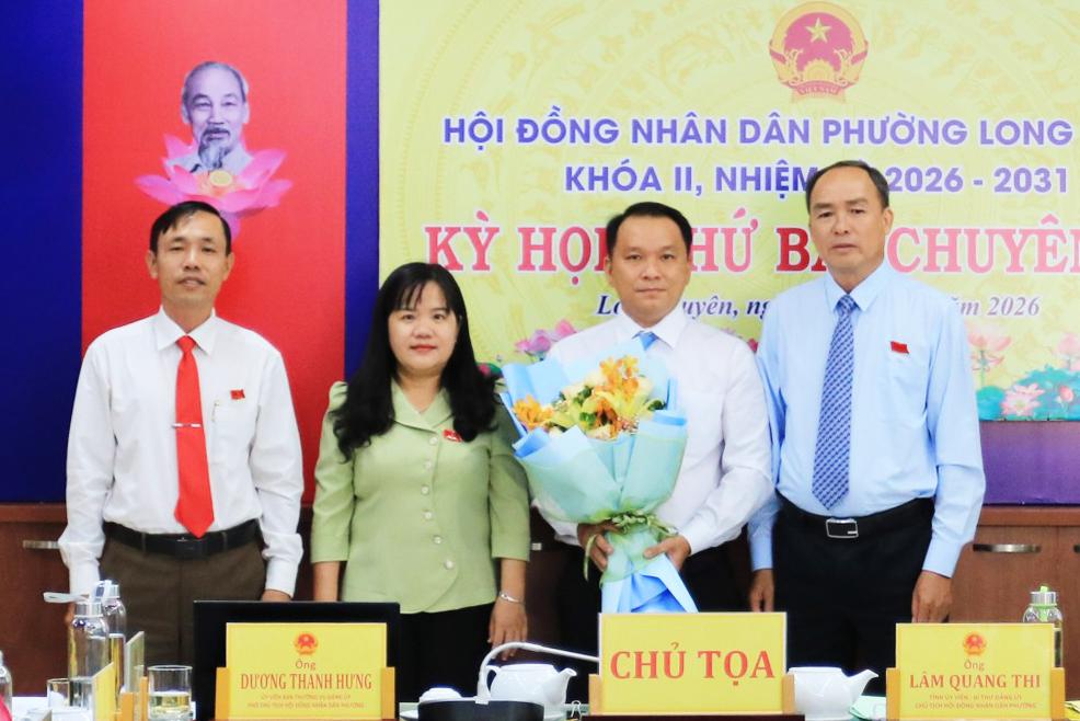 Chủ tọa kỳ họp và Chủ tịch UBND phường Long Xuyên Đoàn Thị Hương Hà tặng hoa chúc mừng ông Đặng Hoàng Vinh
