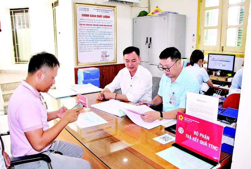 C&aacute;n bộ Trung t&acirc;m Phục vụ h&agrave;nh ch&iacute;nh c&ocirc;ng phường Quảng Y&ecirc;n (tỉnh Quảng Ninh) hỗ trợ người d&acirc;n l&agrave;m thủ tục h&agrave;nh ch&iacute;nh. (Ảnh QUANG THỌ)  
