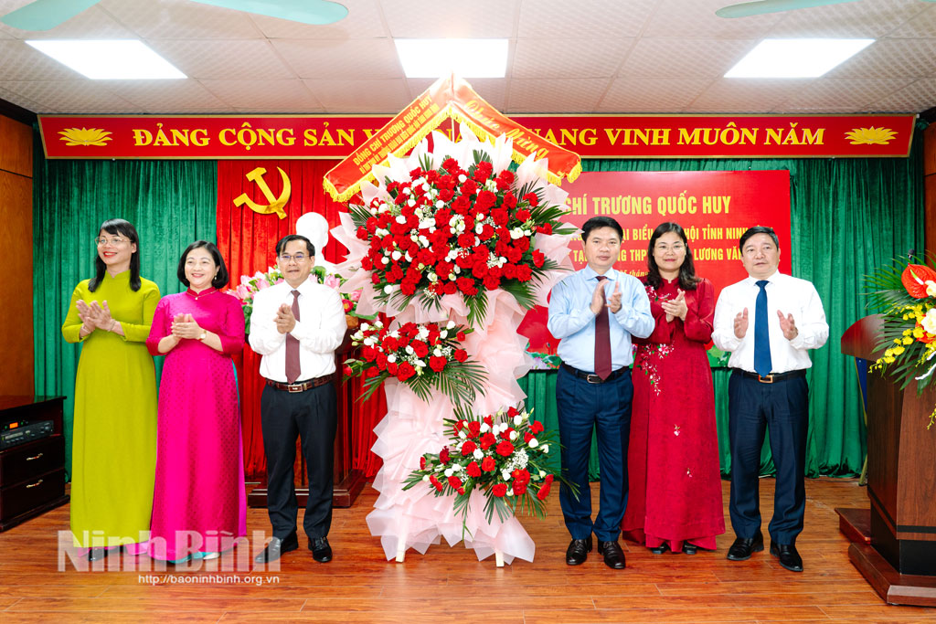 Đồng chí Bí thư Tỉnh ủy Trương Quốc Huy và đoàn công tác tặng hoa chúc mừng thầy và trò Trường THPT chuyên Lương Văn Tụy.