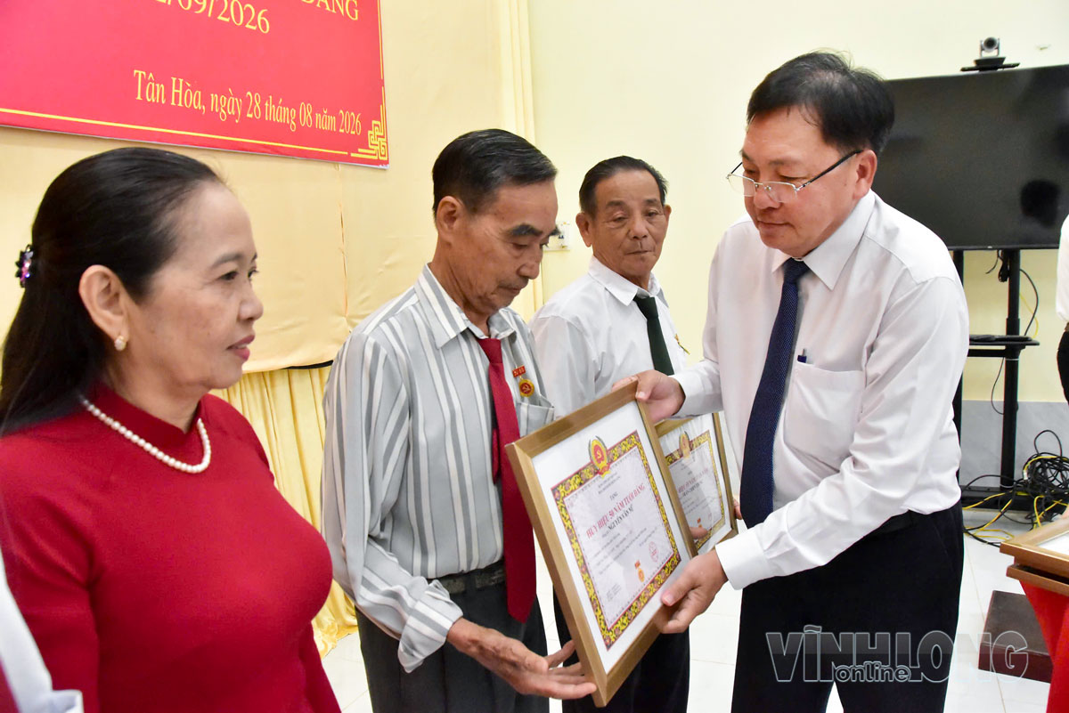 Đồng chí Tăng Chí Huấn, Tỉnh ủy viên, Phó Giám đốc Báo và phát thanh, truyền hình Vĩnh Long, Giám đốc Trung tâm Báo Vĩnh Long trao Huy hiệu 50 năm tuổi Đảng cho đảng viên Nguyễn Văn Nữ. Ảnh: MỸ NHÂN