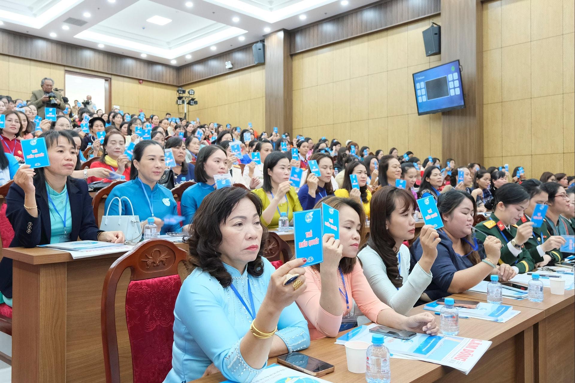 Các đại biểu giơ thẻ biểu quyết Nghị quyết Đại hội