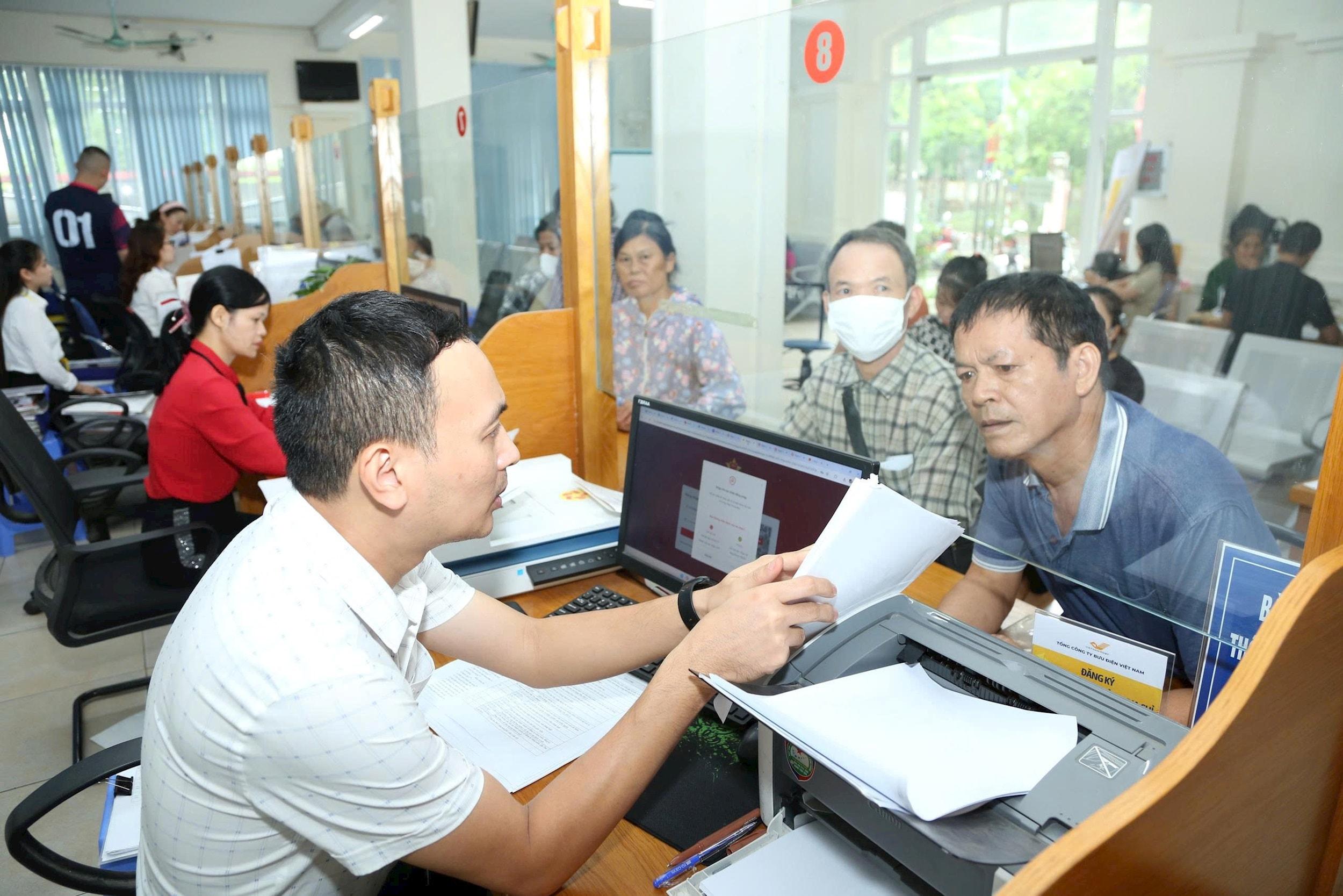 Giải quyết thủ tục hành chính cho người dân tại xã Quang Minh. Ảnh: Phạm Hùng