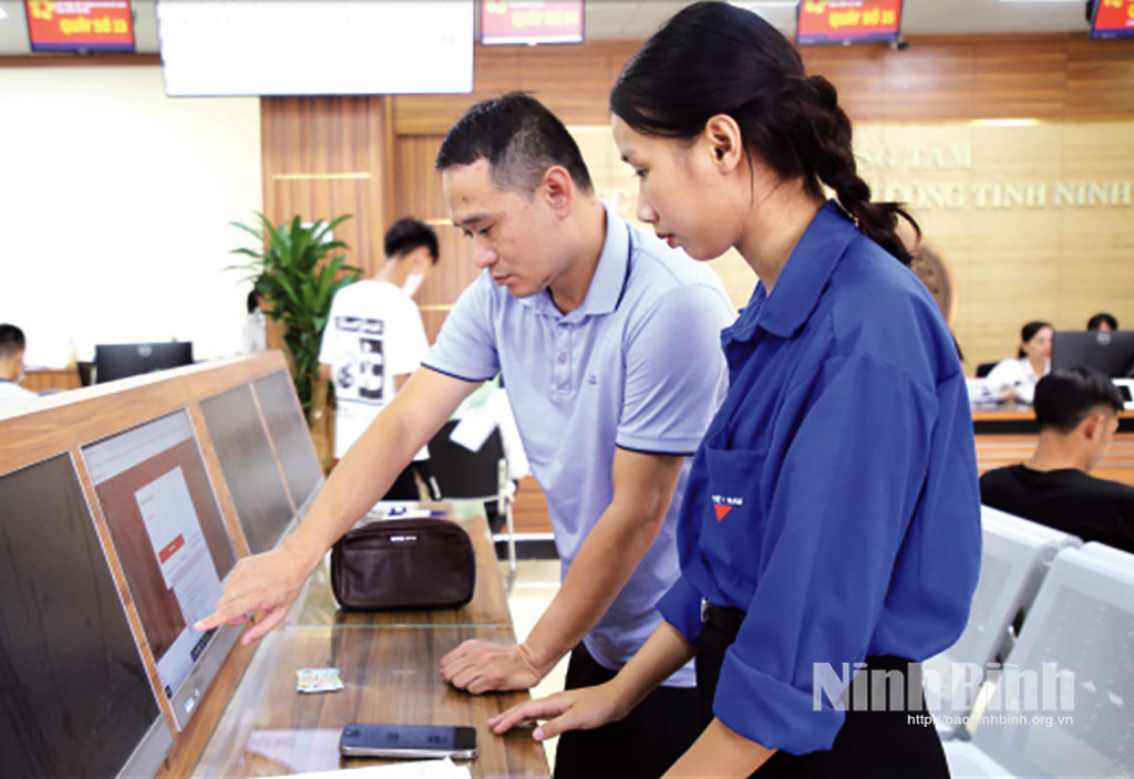 Đoàn viên, thanh niên phường Hoa Lư hỗ trợ người dân tra cứu thủ tục hành chính tại Trung tâm Phục vụ hành chính công tỉnh.