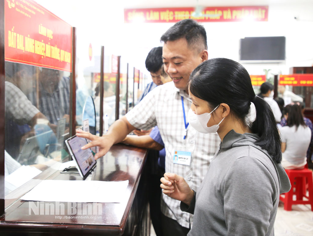 Cán bộ Trung tâm Phục vụ hành chính công xã Ý Yên hướng dẫn người dân tra cứu thủ tục hành chính điện tử.