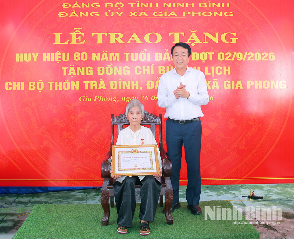 Đồng chí Nguyễn Thanh Bình, Phó Bí thư Tỉnh ủy, Chủ tịch UBND tỉnh trao Huy hiệu 80 năm tuổi Đảng cho đồng chí Bùi Thị Lịch, đảng viên Chi bộ Trà Đính, Đảng bộ xã Gia Phong.