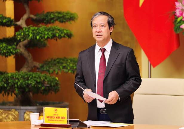 A person in a suit holding a piece of paper  Description automatically generated