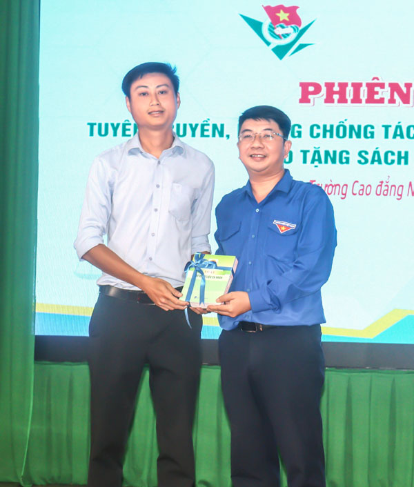 Anh Nguyễn Minh Thiện (bên phải) với hoạt động trao tặng sách về pháp luật để trang bị “Tủ sách pháp luật trong thanh niên”.