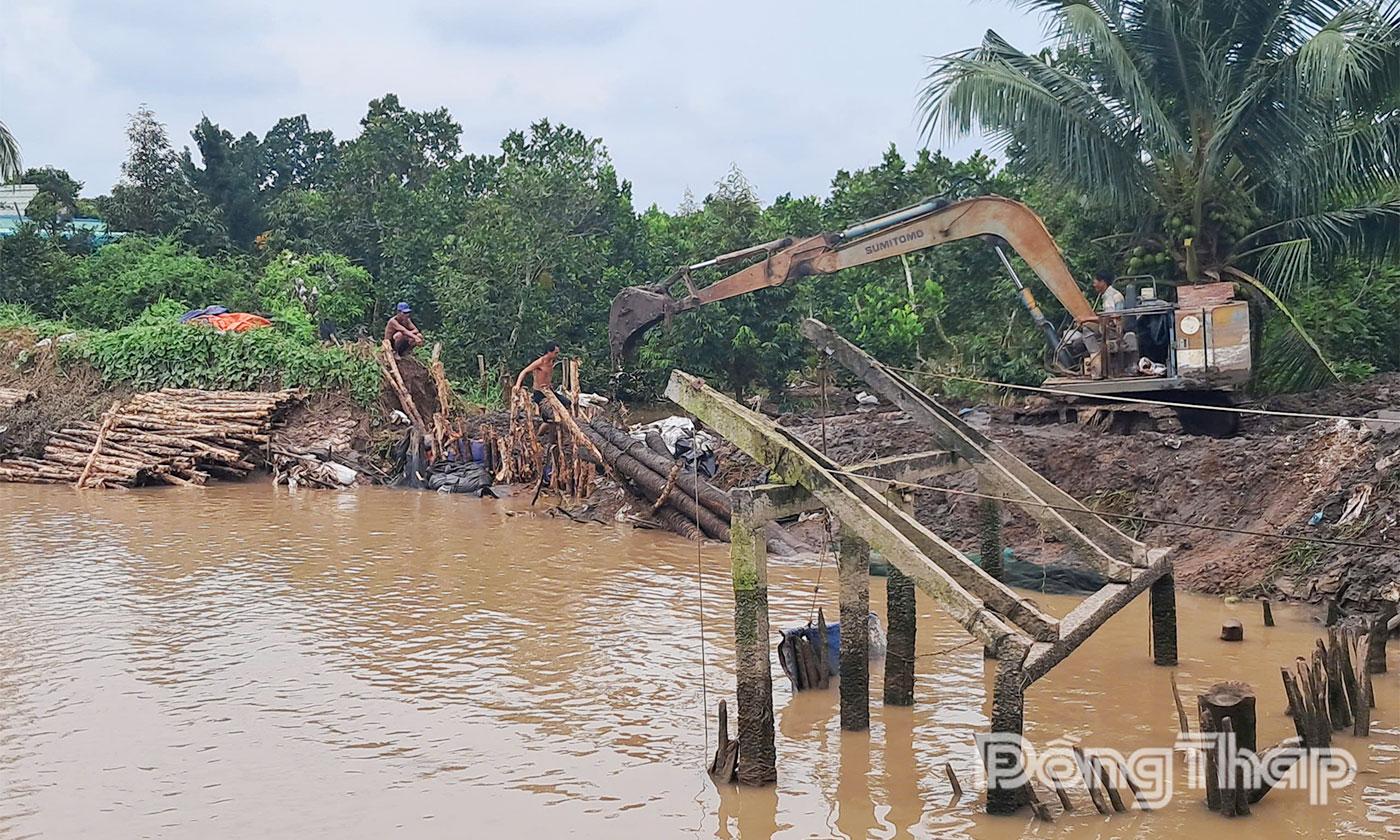Người dân ấp Tân An, xã Hiệp Đức khắc phục sự cố vỡ đê bao do đợt triều cường vừa qua gây ra.
