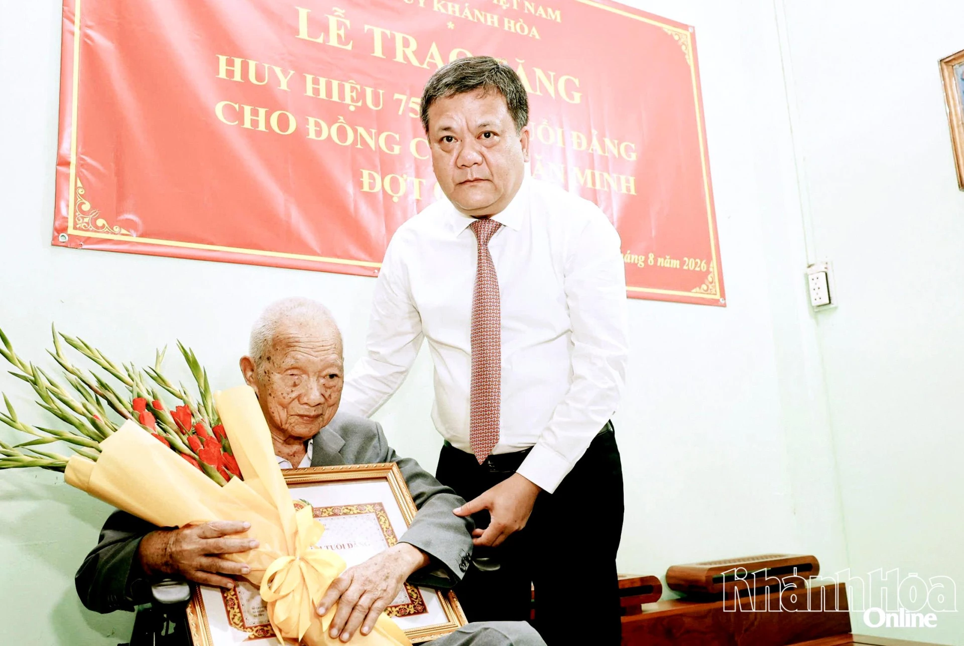Bí thư Tỉnh ủy Trần Phong trao Huy hiệu 75 năm tuổi Đảng và tặng hoa chúc mừng đảng viên Lê Văn Minh.