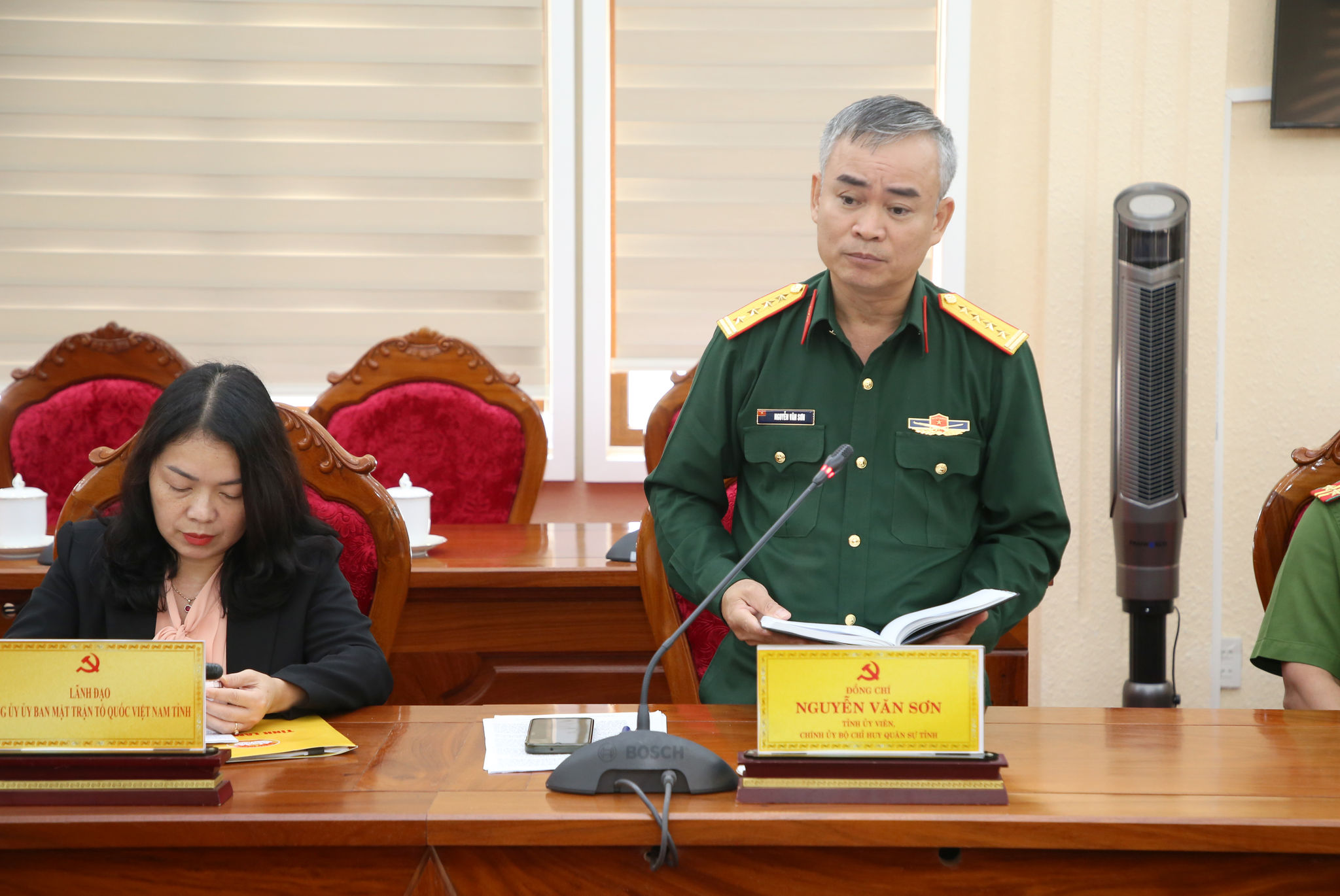 Đại tá Nguyễn Văn Sơn, TỈnh ủy viên, Chính ủy Bộ Chỉ huy Quân sự tỉnh báo cáo tình hình công tác tại hội nghị