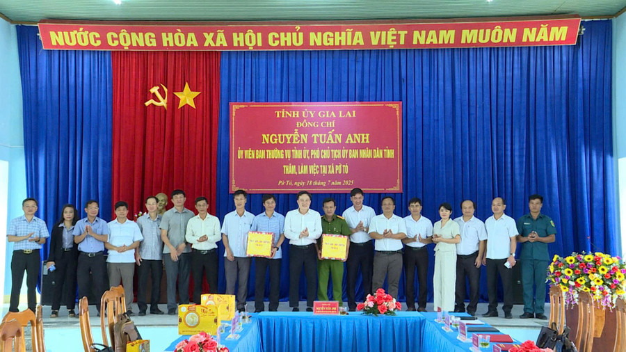Phó Chủ tịch UBND tỉnh Nguyễn Tuấn Anh (thứ 10 từ trái sang) tặng quà cho tập thể lãnh đạo xã Pờ Tó. Ảnh: Phi Long