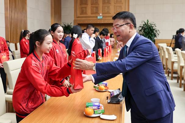 A person handing a red packet to a child  Description automatically generated