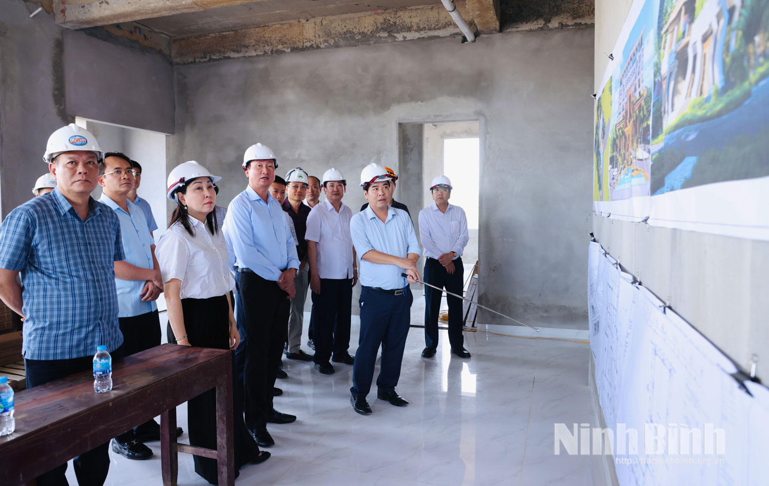 Đồng chí Bí thư Tỉnh ủy Trần Huy Tuấn và các đồng chí lãnh đạo tỉnh nghe đơn vị thi công báo cáo tiến độ xây dựng công trình Nhà khách tỉnh Ninh Bình.