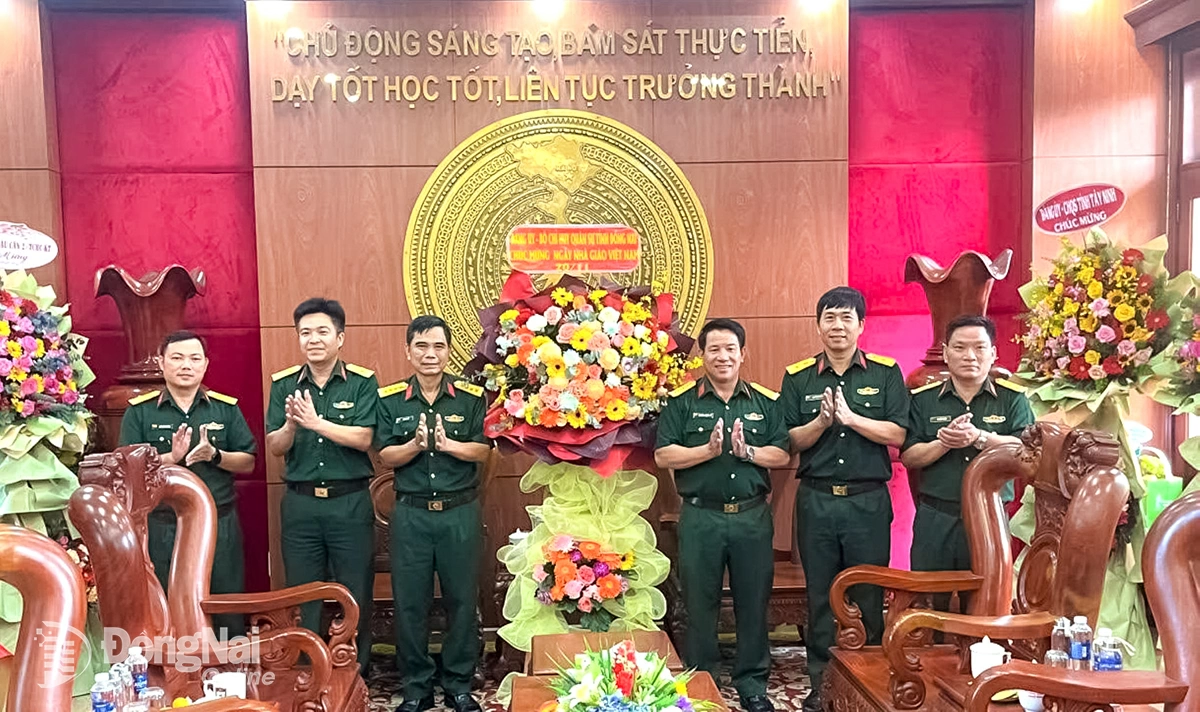 Đại tá Bùi Văn Sỹ, Phó Chính ủy Bộ Chỉ huy Quân sự tỉnh Đồng Nai tặng hoa, quà chúc mừng thầy, cô giáo Trường Quân sự Quân khu 7. Ảnh: ĐVCC  
