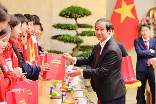 A person handing a bag to a group of people  Description automatically generated