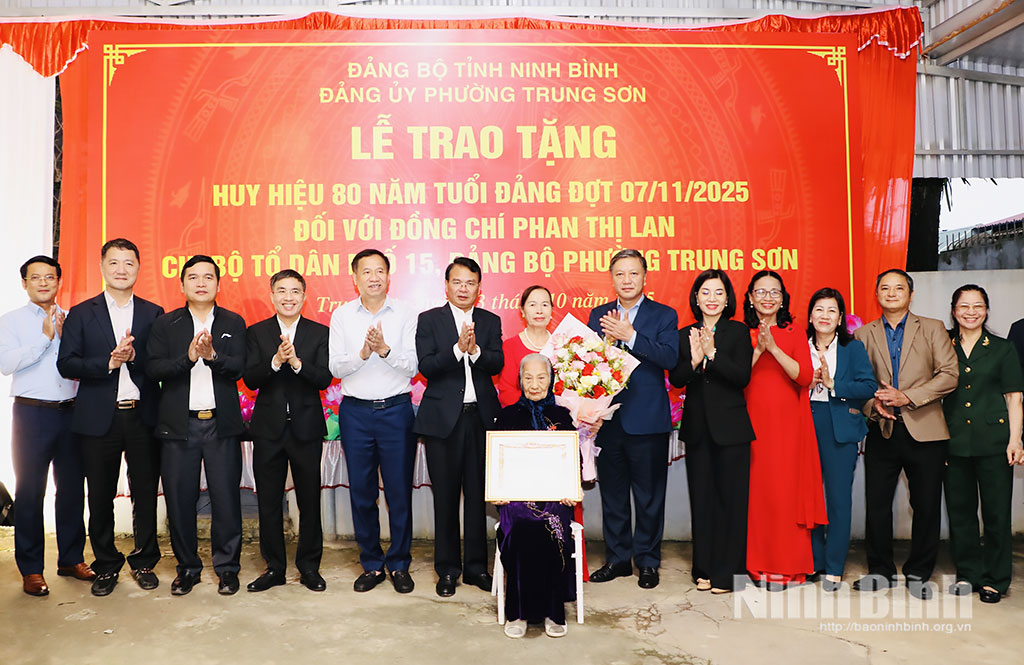 Đồng chí Đặng Xuân Phong, Ủy viên Trung ương Đảng, Bí thư Tỉnh ủy, Trưởng Đoàn đại biểu Quốc hội tỉnh và các đồng chí lãnh đạo tặng hoa chúc mừng đảng viên Phan Thị Lan, chi bộ Tổ dân phố 15, phường Trung Sơn.