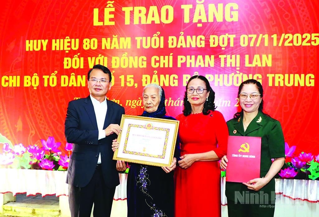 Đồng chí Đặng Xuân Phong, Ủy viên Trung ương Đảng, Bí thư Tỉnh ủy, Trưởng Đoàn đại biểu Quốc hội tỉnh trao tặng Huy hiệu 80 năm tuổi Đảng cho đảng viên Phan Thị Lan (thứ 2 từ trái sang), Chi bộ Tổ dân phố 15, phường Trung Sơn. Ảnh: Đức Lam