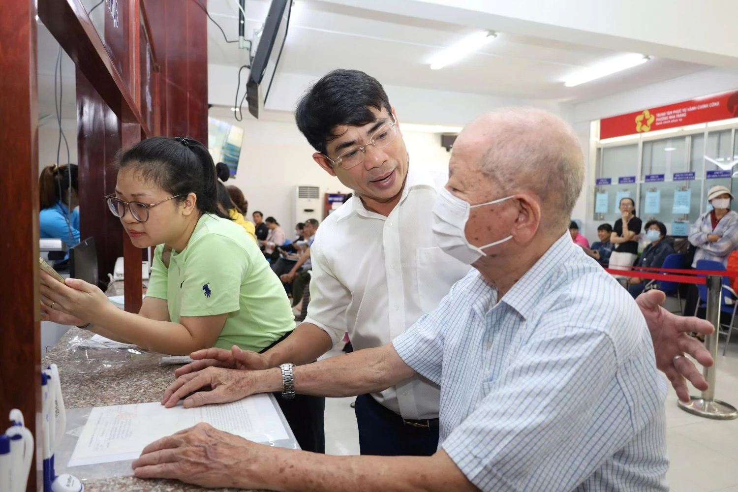 Ông Trần Xuân Tây - Bí thư Đảng ủy phường Nha Trang hướng dẫn người dân thực hiện các thủ tục hành chính tại Trung tâm Phục vụ hành chính công phường.