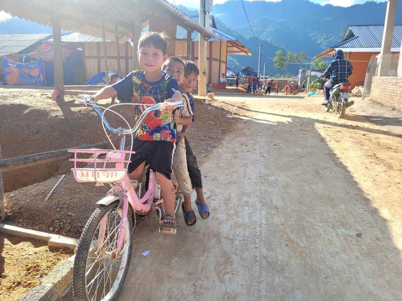 Trẻ em vui đùa trước những ngôi nhà mới tại khu tái định cư, niềm vui giản dị trên miền đất bình yên. Trẻ em vui đùa trước những ngôi nhà mới tại khu tái định cư, niềm vui giản dị trên miền đất bình yên.