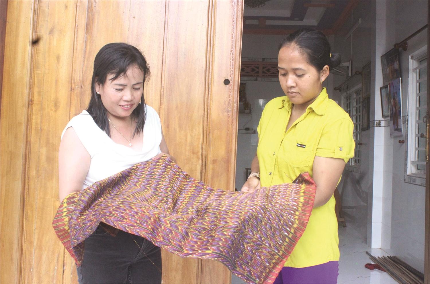 Chị Neáng Chanh Ty (bên trái) tự hào chia sẻ về các sản phẩm thổ cẩm của làng nghề