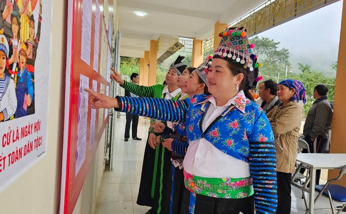 Cử tri xã biên giới Nhi Sơn (Thanh Hóa) xem danh sách cử tri và danh sách ứng cử được niêm yết công khai tại khu vực bỏ phiếu.(ảnh Quỳnh Trâm)