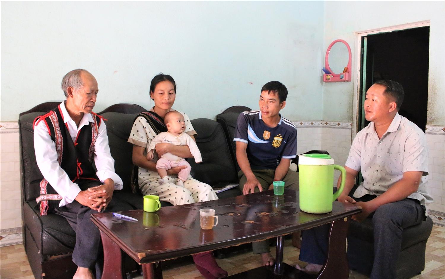 Ông A Kham (ngoài cùng bên trái), già làng, Người có uy tín thôn Đăk Dé, xã Ngọk Tụ thường xuyên đến từng nhà truyên truyền, vận động bà con chấp hành nghiêm các quy định của pháp luật. (Ảnh: Ngọc Chí) 