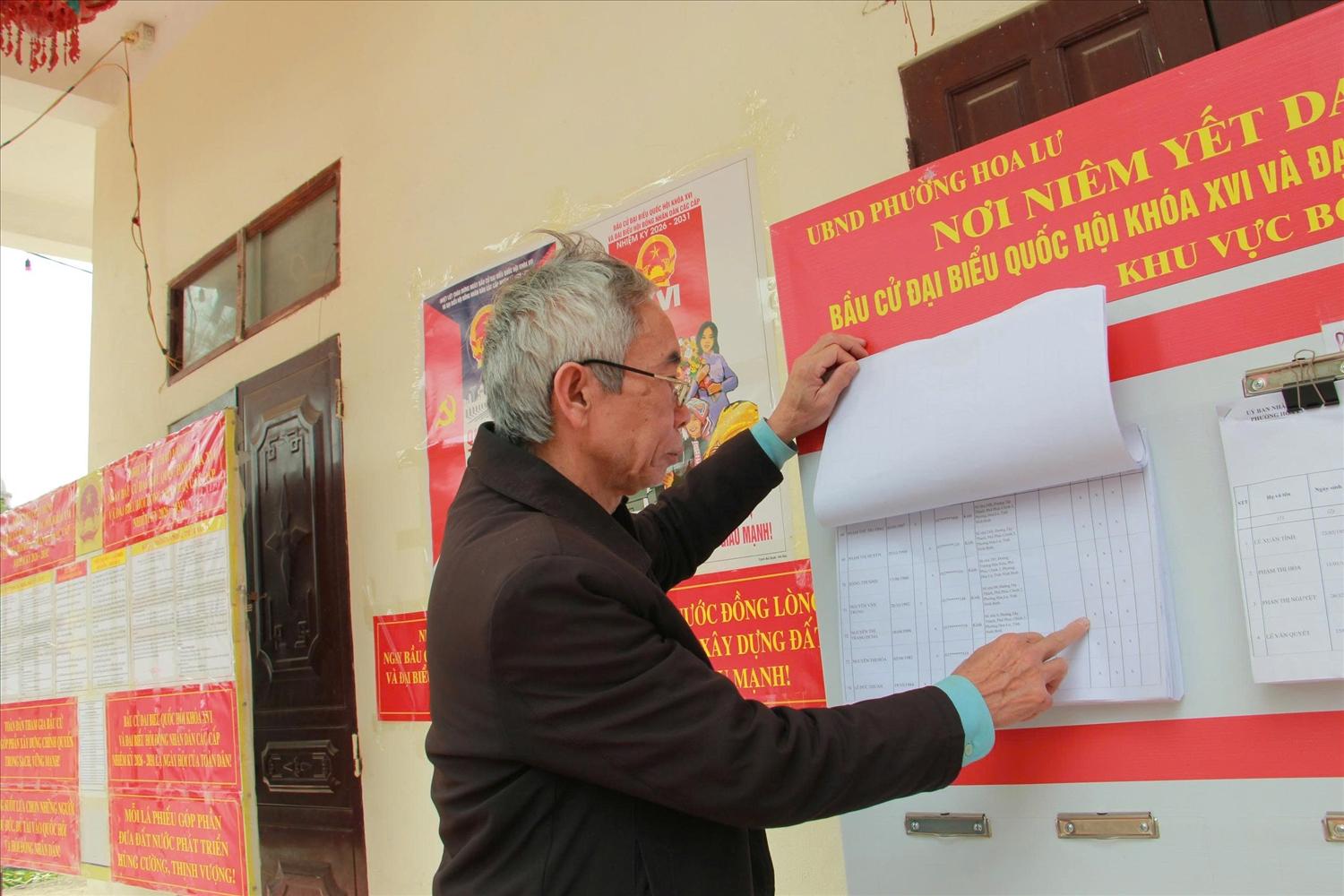 Cử tri phường Hoa Lư xem danh sách và tiểu sử các ứng cử viên được niêm yết tại khu vực bỏ phiếu.