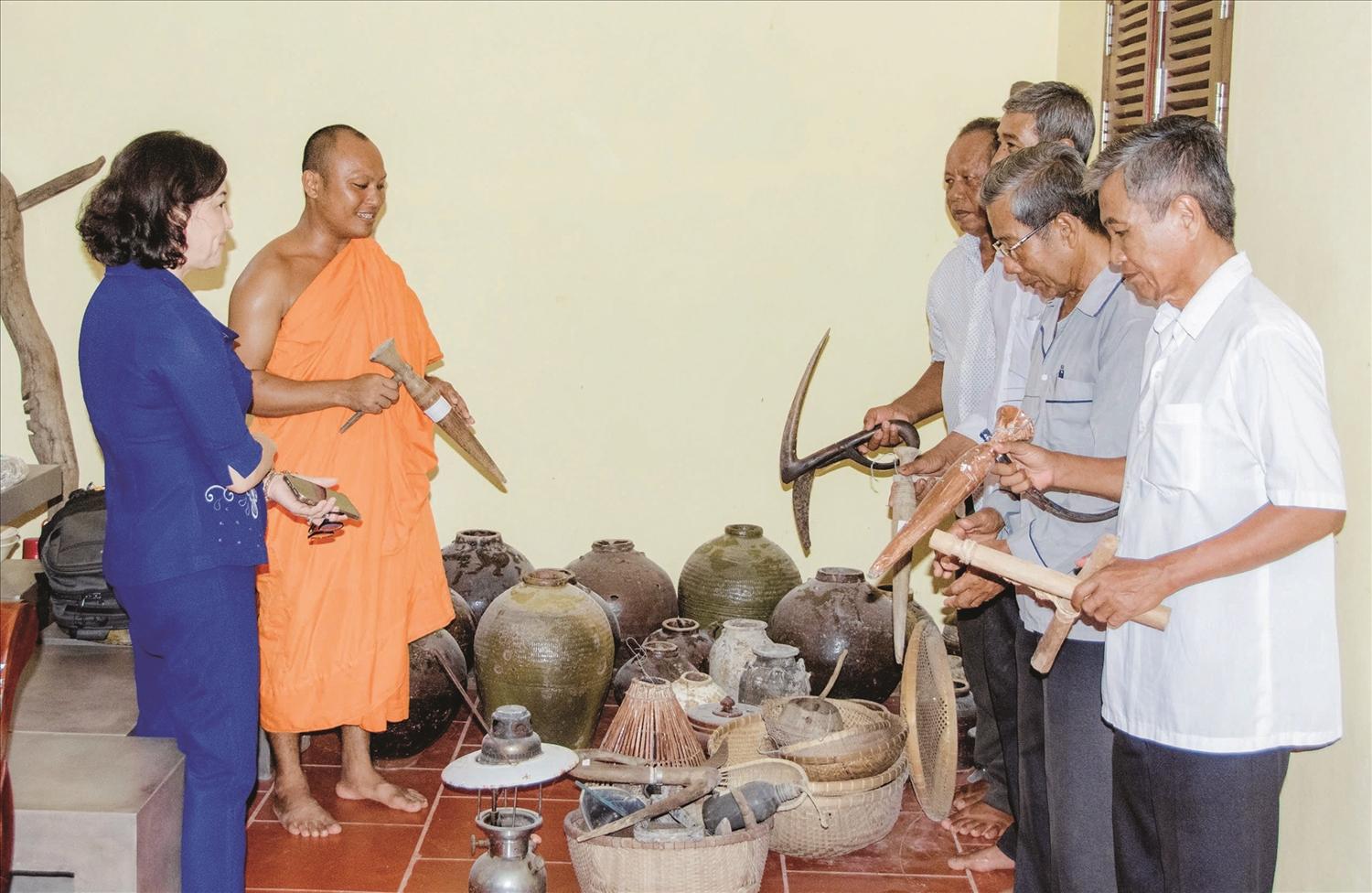 Đại đức Trương Văn Tuấn cùng các Phật tử bên những nông cụ do chính Đại đức sưu tầm