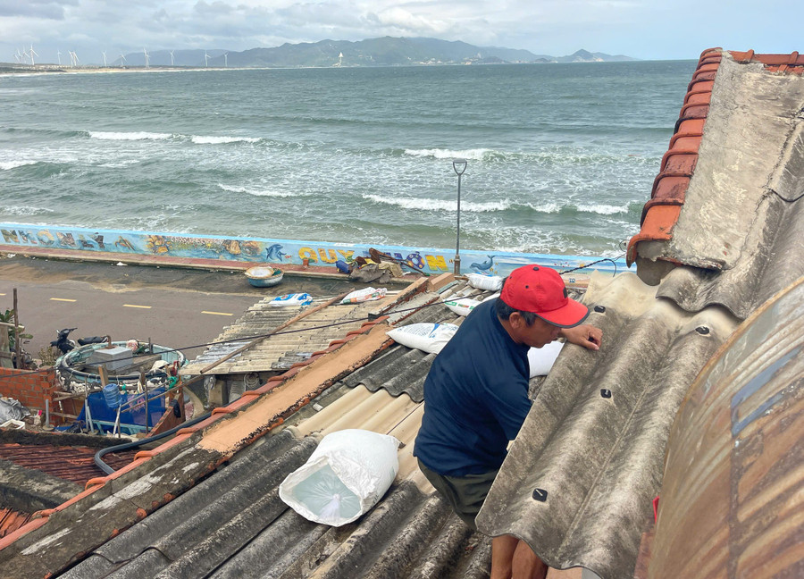 Người dân làng biển Nhơn Lý kiểm tra chằng chống mái nhà. Ảnh: Ngọc Nhuận nguoi-dan-lang-bien-nhon-ly-kiem-tra-mai-nhajpg.jpg