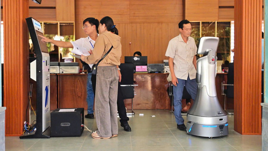 Người dân hào hứng tương tác với robot phục vụ hành chính công tại phường Hội Phú. Ảnh: Bá Bính z7045332161502-6a809bb7111b392c878bdf97de3ed34f.jpg