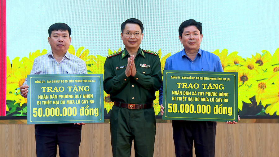 Đại tá Đoàn Ngọc Báu-Bí thư Đảng ủy, Chính ủy Ban Chỉ huy BĐBP tỉnh trao 100 triệu đồng của nhà tài trợ cho đại diện lãnh đạo phường Quy Nhơn và xã Tuy Phước Đông. Ảnh: Mạnh Hà bp4.jpg