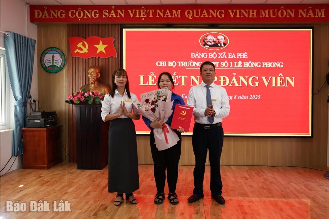 Phó Bí thư Thường trực Đảng ủy xã Ea Phê Võ Phú Hùng trao quyết định kết nạp đảng cho đảng viên Nguyễn Thị Yến Nhi.