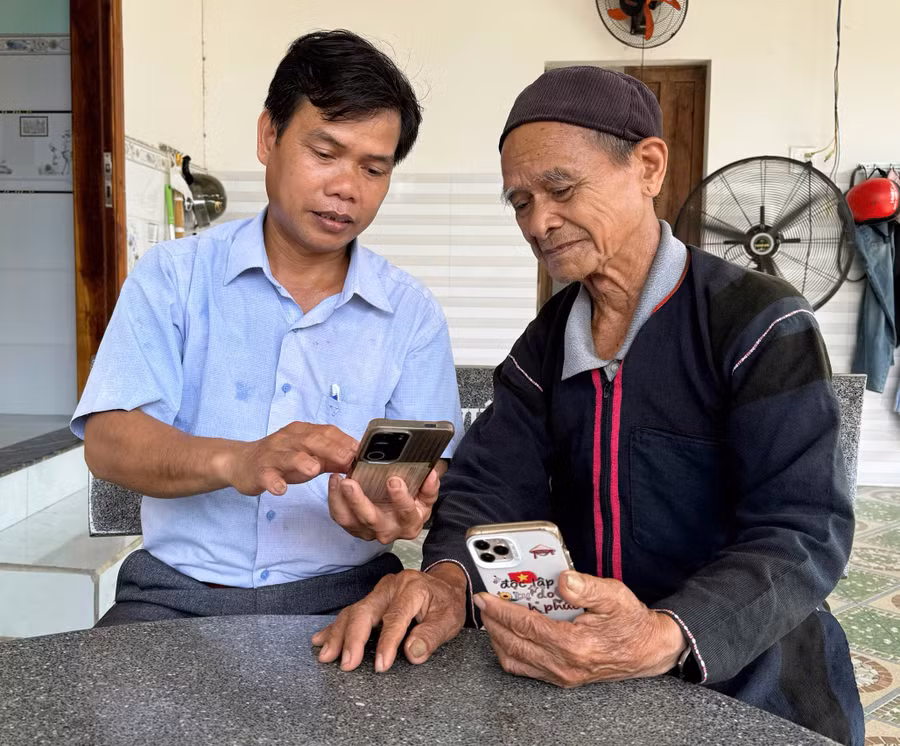 Trưởng ban Xây dựng Đảng xã Kim Sơn trao đổi với già làng Đinh Sinh về nhận diện các thông tin xấu, độc trên mạng xã hội. Ảnh: N.H 8-7501.jpg