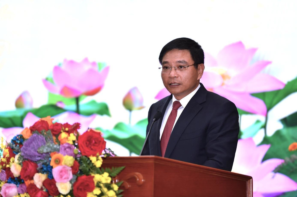 A person standing at a podium with flowers  AI-generated content may be incorrect.