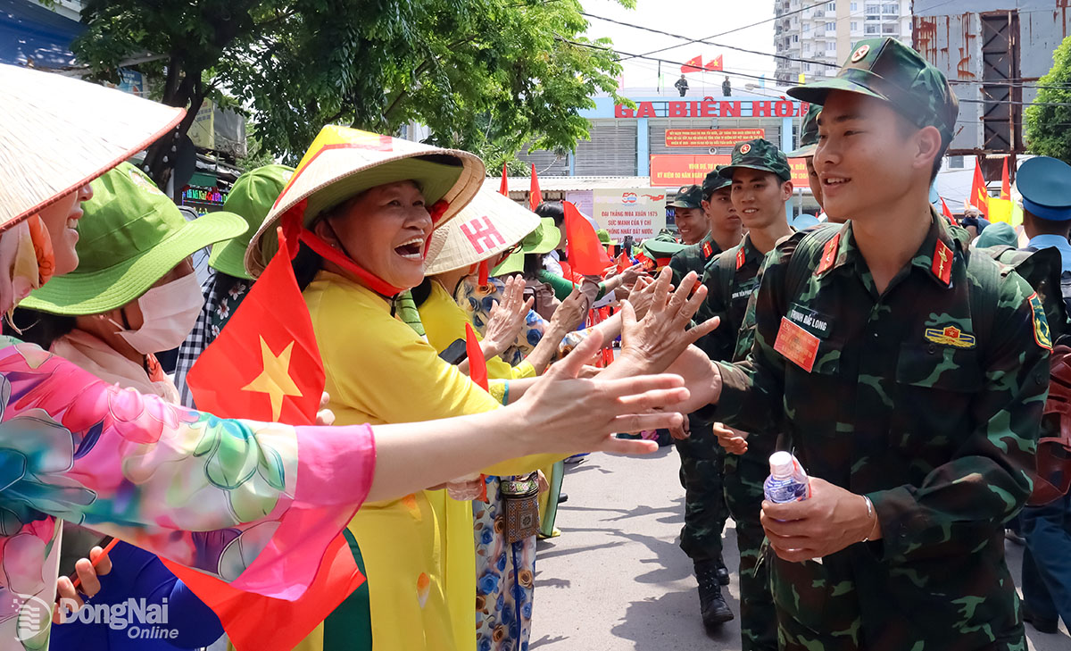 Người dân Đồng Nai chào đón các chiến sĩ tham gia Lễ kỷ niệm 50 năm ngày Giải phóng miền Nam, thống nhất đất nước. Ảnh: Nguyệt Hà