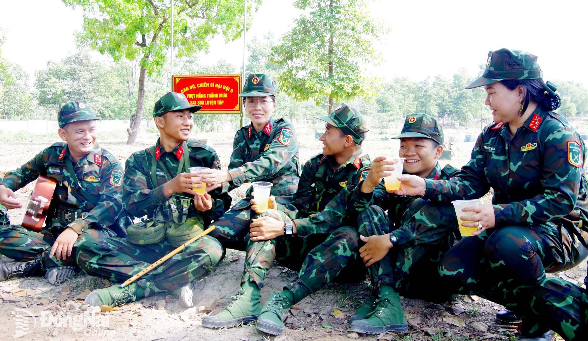 Đại úy chuyên nghiệp Trần Thị Hạnh (bìa phải) và hội viên phụ nữ trao những ly nước mát giúp chiến sĩ mới yên tâm huấn luyện. Ảnh: Nguyệt Hà