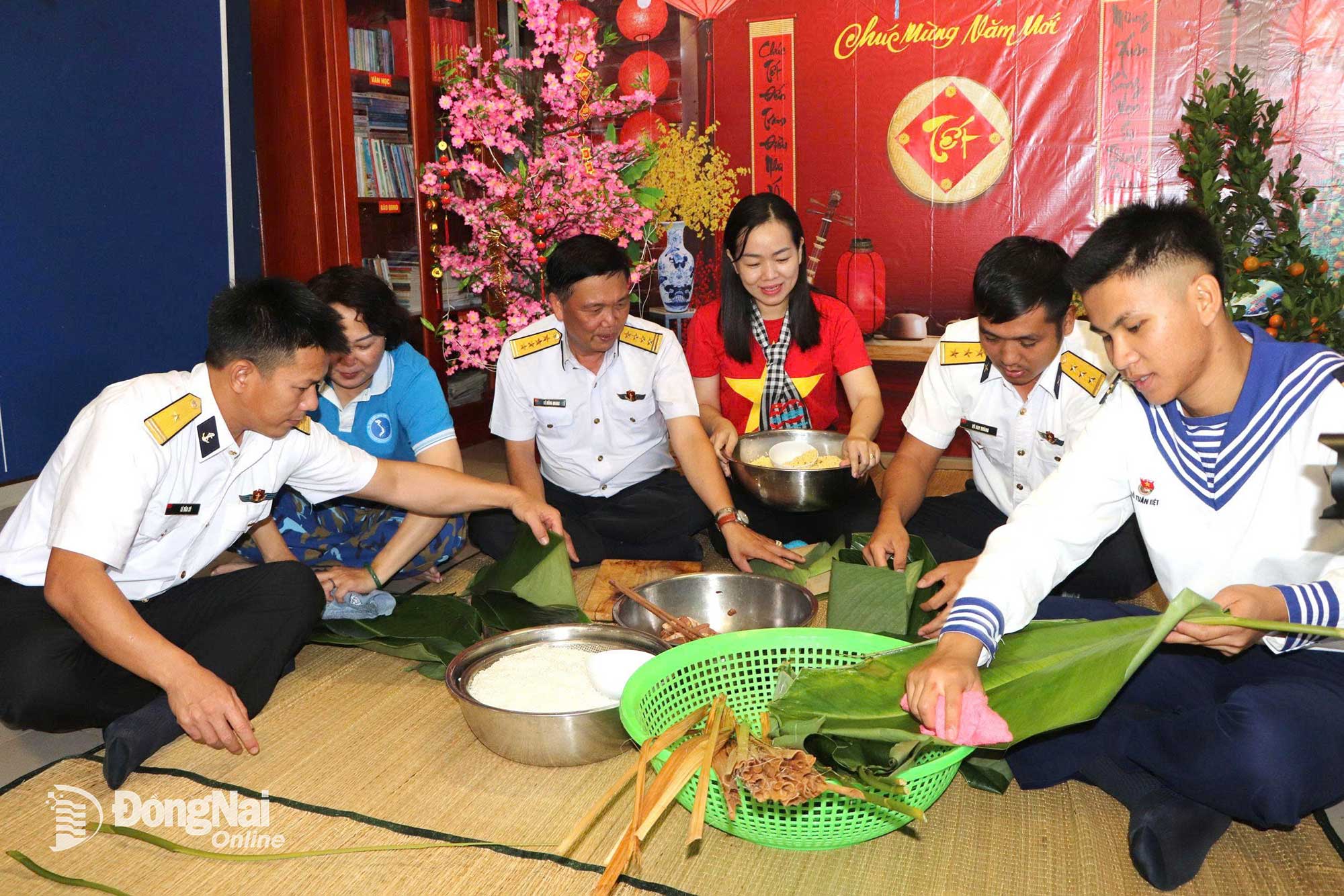 Đo&agrave;n c&ocirc;ng t&aacute;c tham gia g&oacute;i b&aacute;nh chưng c&ugrave;ng c&aacute;c c&aacute;n bộ, chiến sĩ nh&agrave; gi&agrave;n. Ảnh: Ngọc Li&ecirc;n  