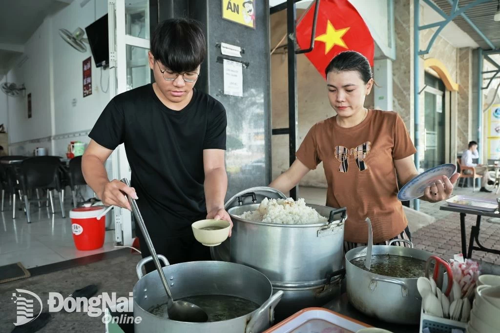 Em Đoàn Nguyên Thắng phụ giúp mẹ bán cơm ở phường Biên Hòa. Để có tiền nuôi 2 anh em Thắng ăn học, mẹ em đã phải thuê mặt bằng để mở quán cơm bán hàng ngày. Ảnh: Công Nghĩa 