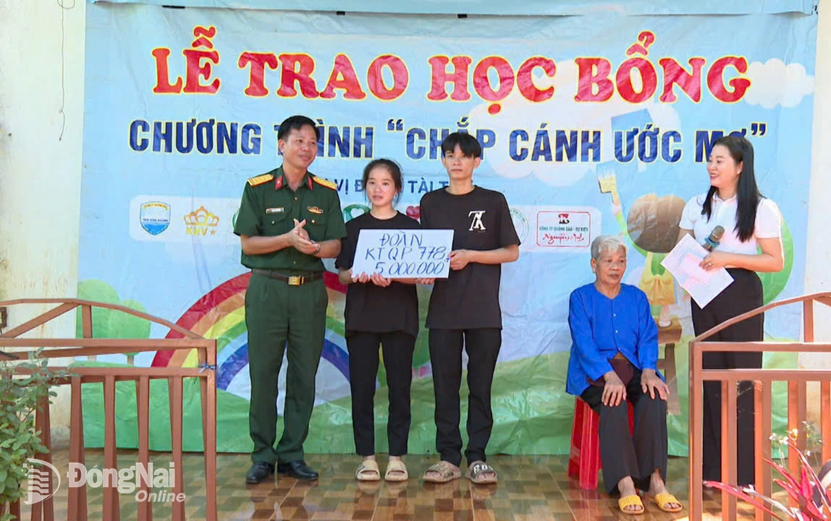 Đại t&aacute; Ho&agrave;ng Văn H&ugrave;ng, Ch&iacute;nh ủy Đo&agrave;n kinh tế - Quốc ph&ograve;ng 778 (Qu&acirc;n khu 7) trao học bổng 5 triệu đồng tiếp sức ước mơ đến trường của hai anh em mồ c&ocirc;i. Ảnh: Ph&uacute; Q&uacute;y
