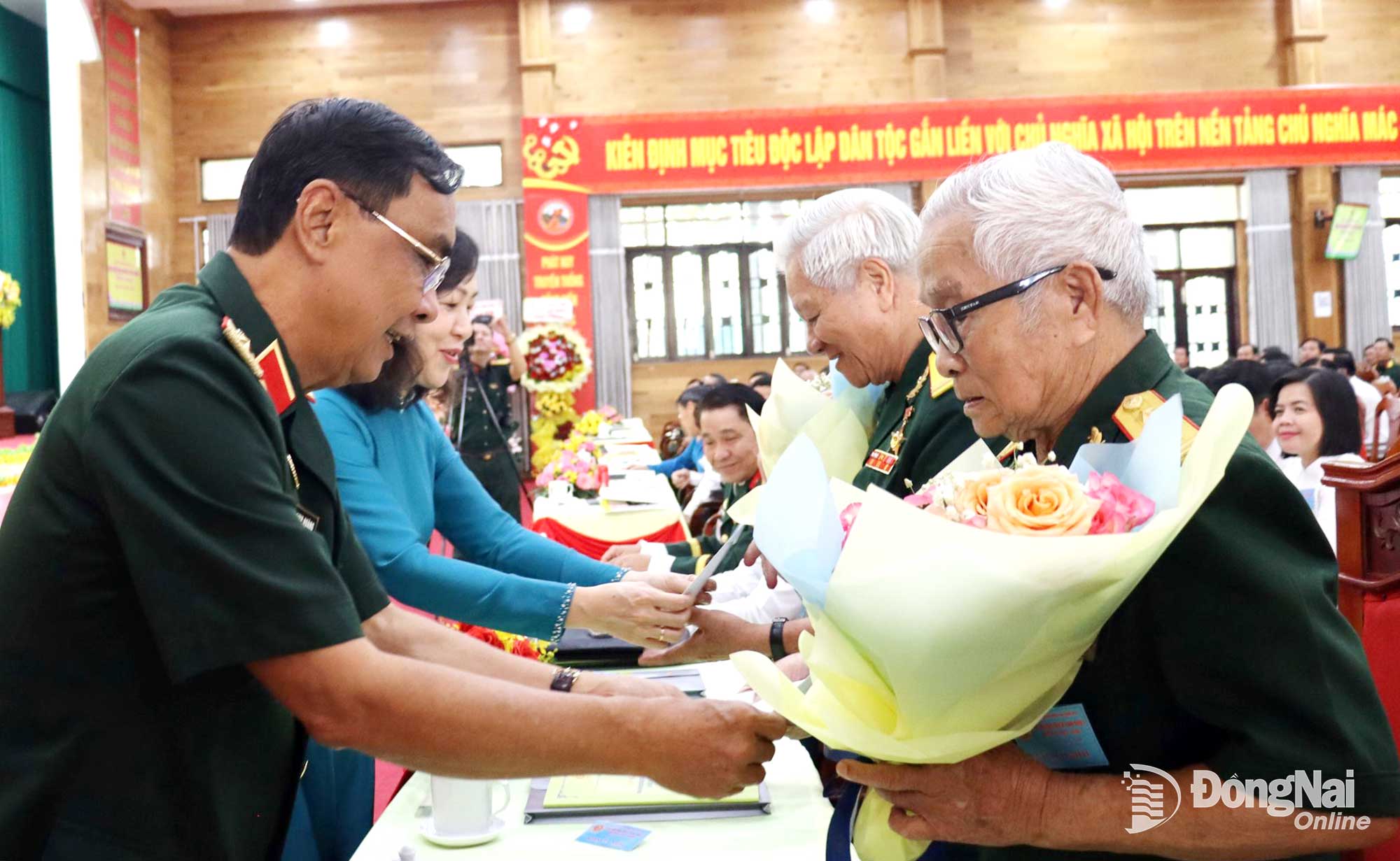 Thiếu tướng Nguyễn Minh Hoàng, Phó Chủ tịch Trung ương Hội Cựu chiến binh Việt Nam và đồng chí Huỳnh Thị Hằng, Phó Bí thư Tỉnh ủy, Chủ tịch Ủy ban MTTQ Việt Nam tỉnh Đồng Nai tặng hoa Anh hùng Lực lượng vũ trang nhân dân Lê Duy Chín và Anh hùng Lao động Nguyễn Đình Trường. Ảnh: Huy Anh