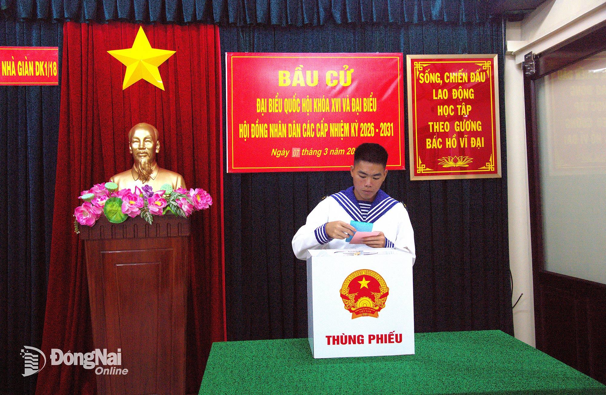 6. Hạ sĩ Ngô Tiến Quảng, chiến sĩ xạ thủ Nhà giàn DK1/18, quê xã Nhơn Trạch, tỉnh Đồng Nai, xếp gọn lá phiếu trước khi bỏ vào thùng phiếu. Người lính trẻ cho biết đây là lần đầu tiên anh được bầu cử giữa biển khơi - một kỷ niệm đặc biệt trong cuộc đời quân ngũ. Ảnh: Văn Đường