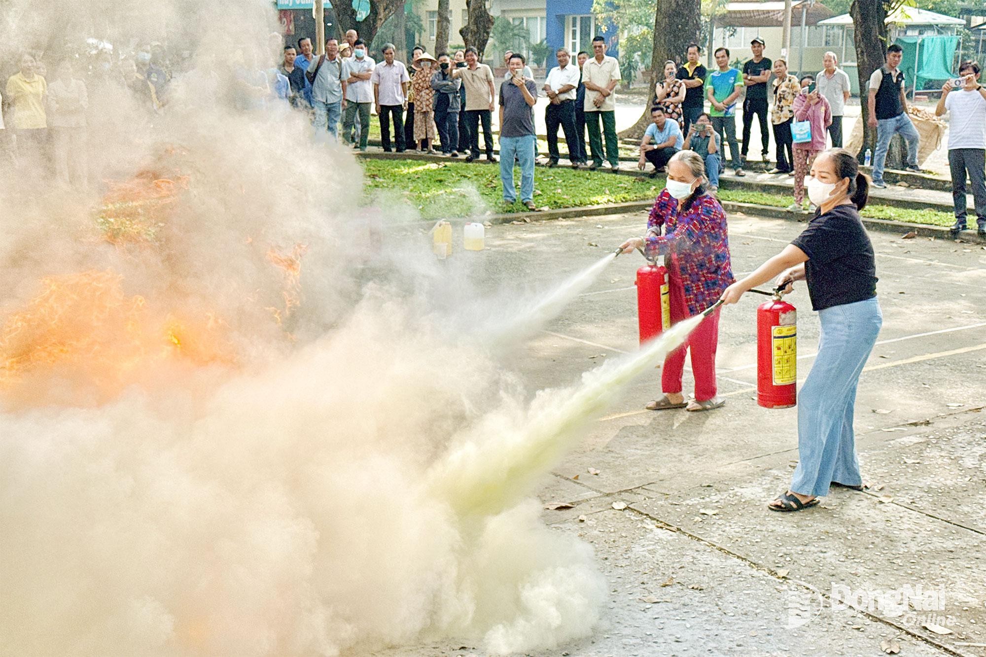 Người d&acirc;n phường Trấn Bi&ecirc;n (tỉnh Đồng Nai) thực h&agrave;nh d&ugrave;ng b&igrave;nh chữa ch&aacute;y x&aacute;ch tay dập tắt đ&aacute;m ch&aacute;y. Ảnh: Đăng T&ugrave;ng