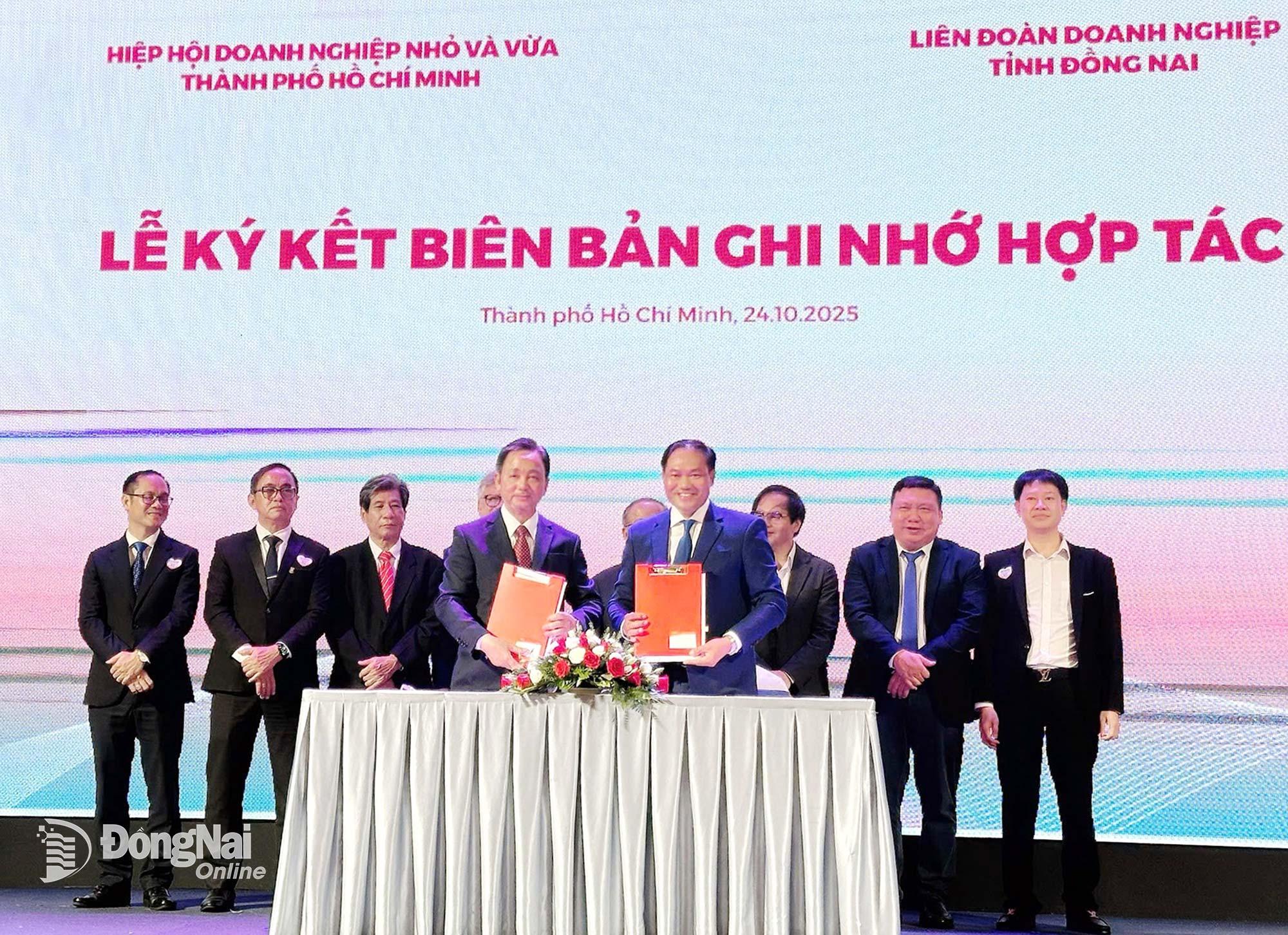 Ông Phạm Văn Triêm, Chủ tịch Hiệp hội Doanh nghiệp nhỏ và vừa Thành phố Hồ Chí Minh (bên trái) và ông Đặng Văn Điềm, Chủ tịch Liên đoàn Doanh nghiệp tỉnh Đồng Nai trao nội dung ký kết hợp tác trước sự chứng kiến của lãnh đạo hai đơn vị. Ảnh: N. Phương