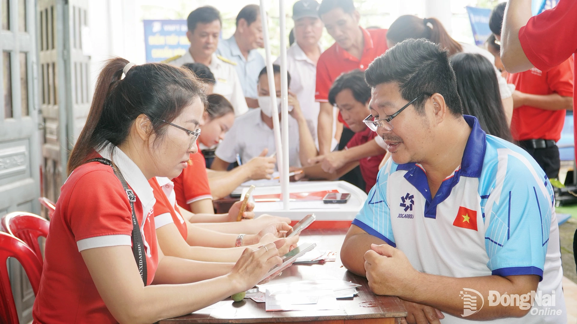 Nhân viên Viettel hỗ trợ người dân khu phố Tân Thành 2, phường Đồng Xoài thực hiện thủ tục hành chính trên môi trường điện tử. Ảnh: Minh Chí