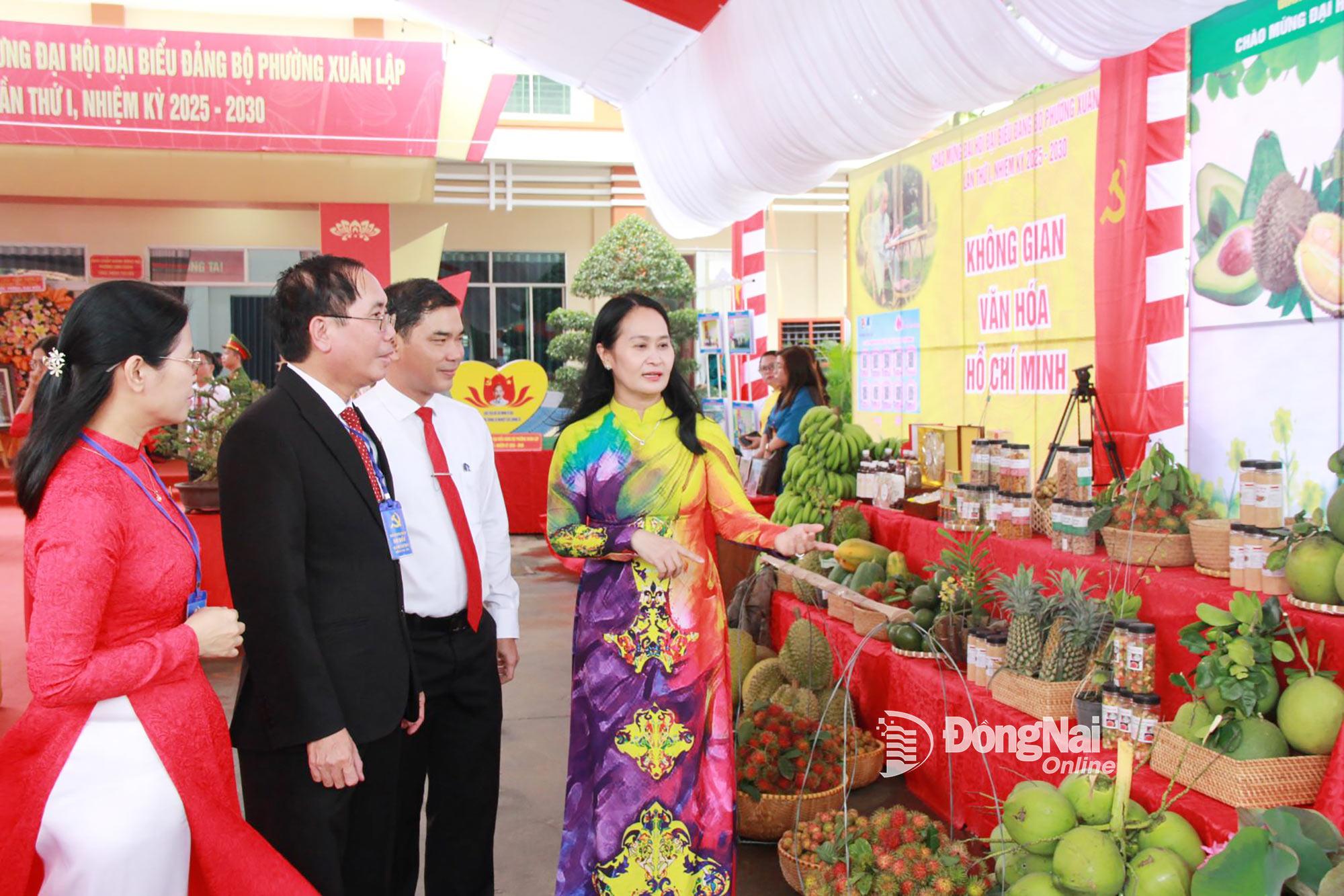 Ủy viên Ban Thường vụ Tỉnh ủy, Bí thư Đảng ủy, Chủ tịch HĐND phường Long Khánh Đặng Minh Nguyệt (bìa phải) và các đại biểu tham quan các gian hàng trưng bày sản phẩm địa phương. Ảnh: Nga Sơn