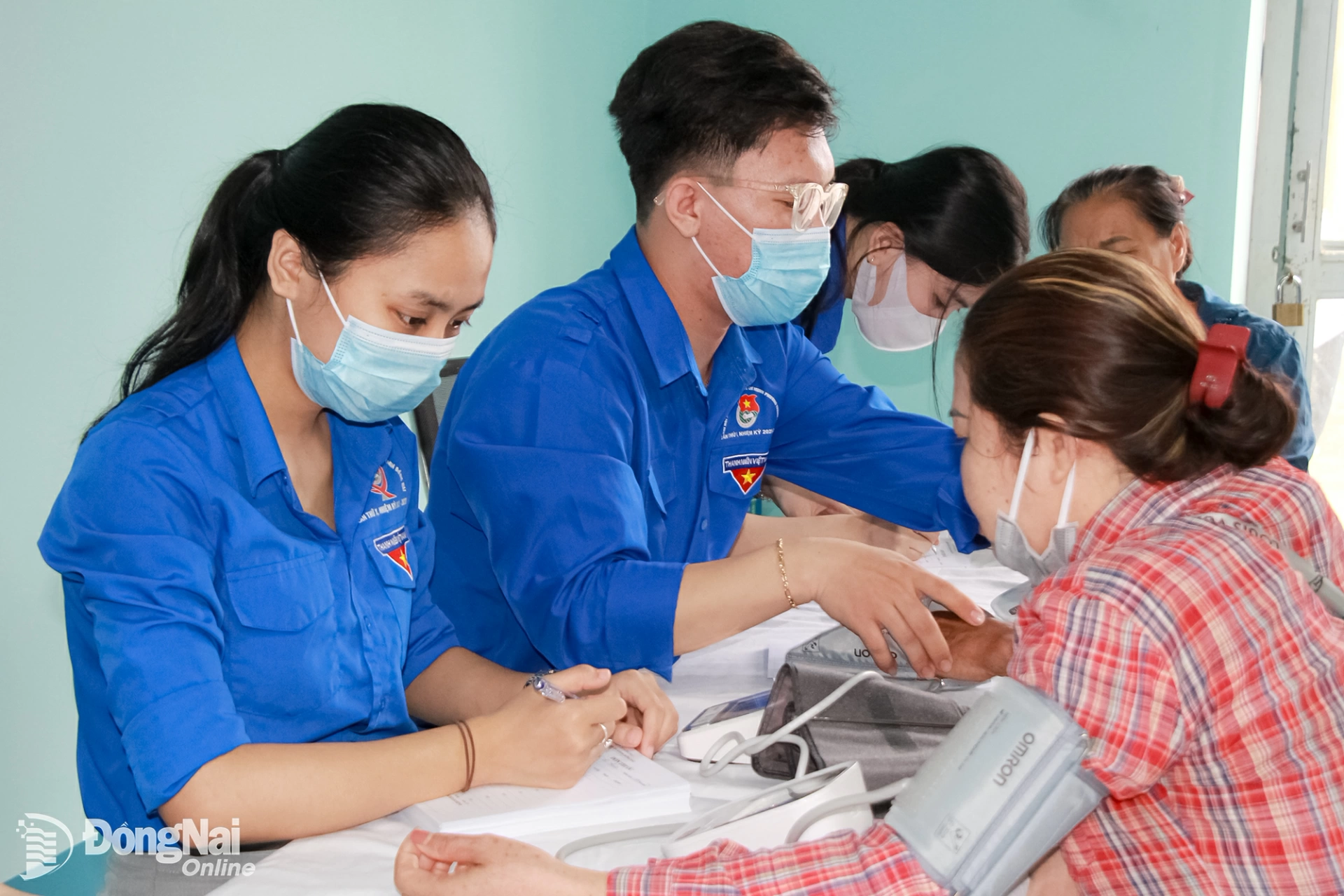 Đoàn viên thanh niên hỗ trợ đo huyết áp cho người dân xã Thanh Sơn trước khi khám bệnh, phát thuốc miễn phí. Ảnh: Nga Sơn