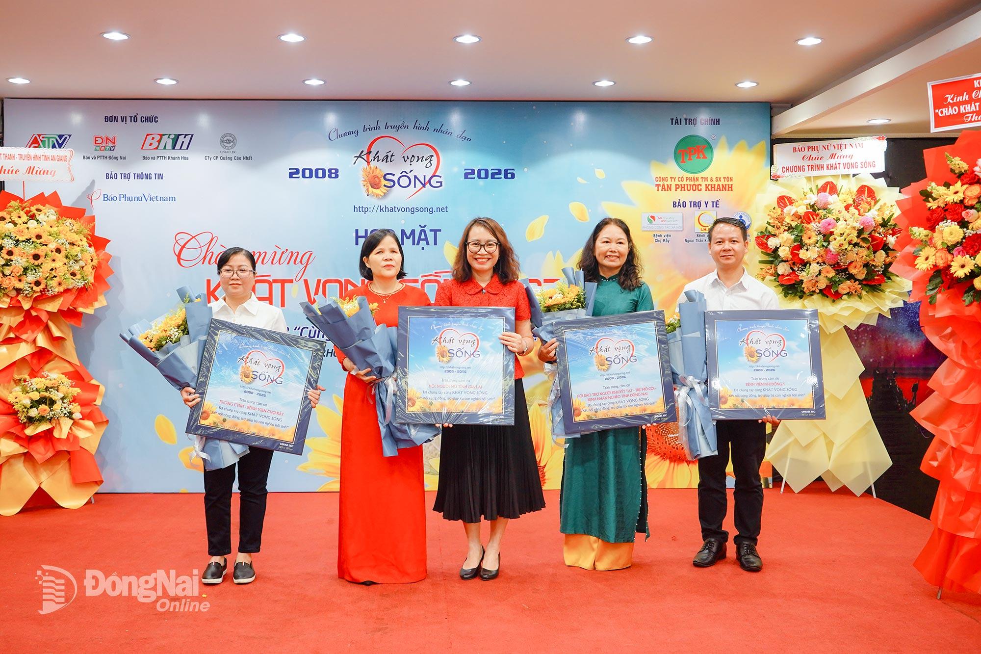 Bà Nguyễn Thị Minh Nhâm, Tỉnh ủy viên, Tổng Biên tập Báo và Phát thanh, Truyền hình Đồng Nai tặng hoa và quà lưu niệm cho 4 đơn vị bảo trợ tiêu biểu của chương trình. Ảnh: Thu Hiền